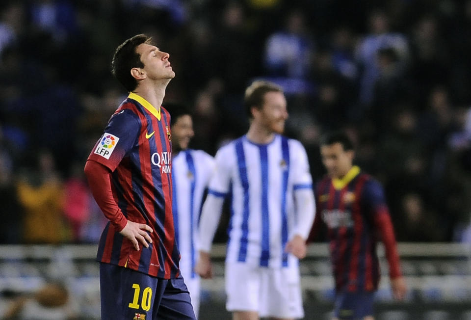 FC Barcelona's Lionel Messi of Argentina, left, reacts after Real Sociedad scored during their Spanish League soccer match, at Anoeta stadium in San Sebastian, Spain, Saturday, Feb. 22, 2014. FC Barcelona lost the match 3-1.(AP Photo/Alvaro Barrientos)