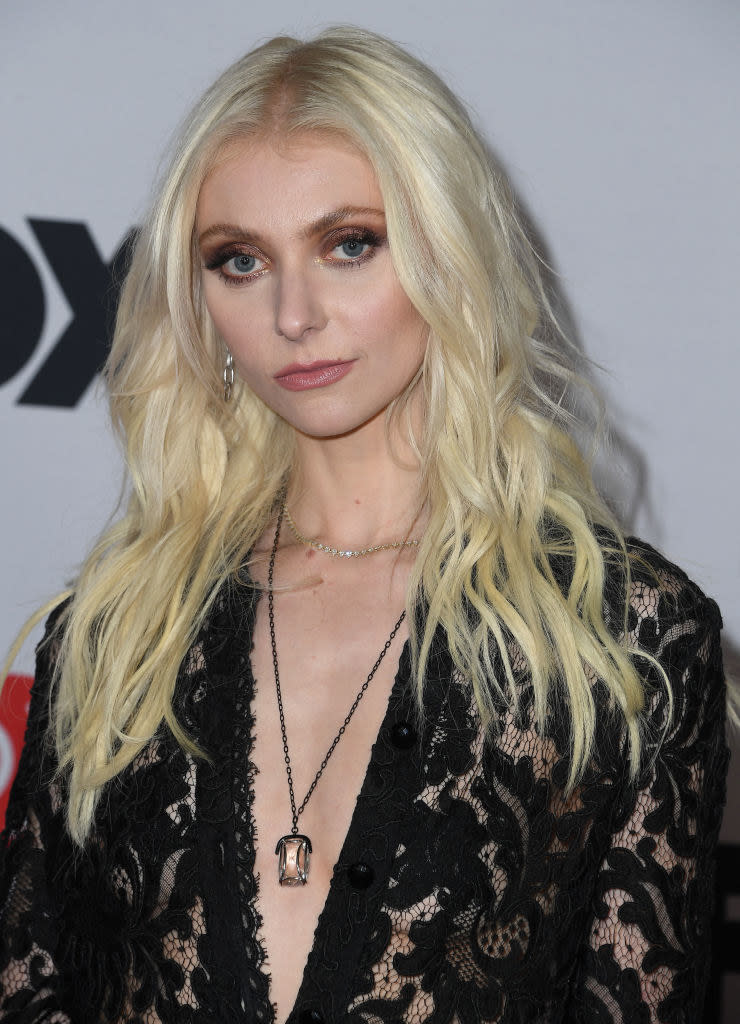Taylor Momsen wearing a lace outfit and gemstone necklace