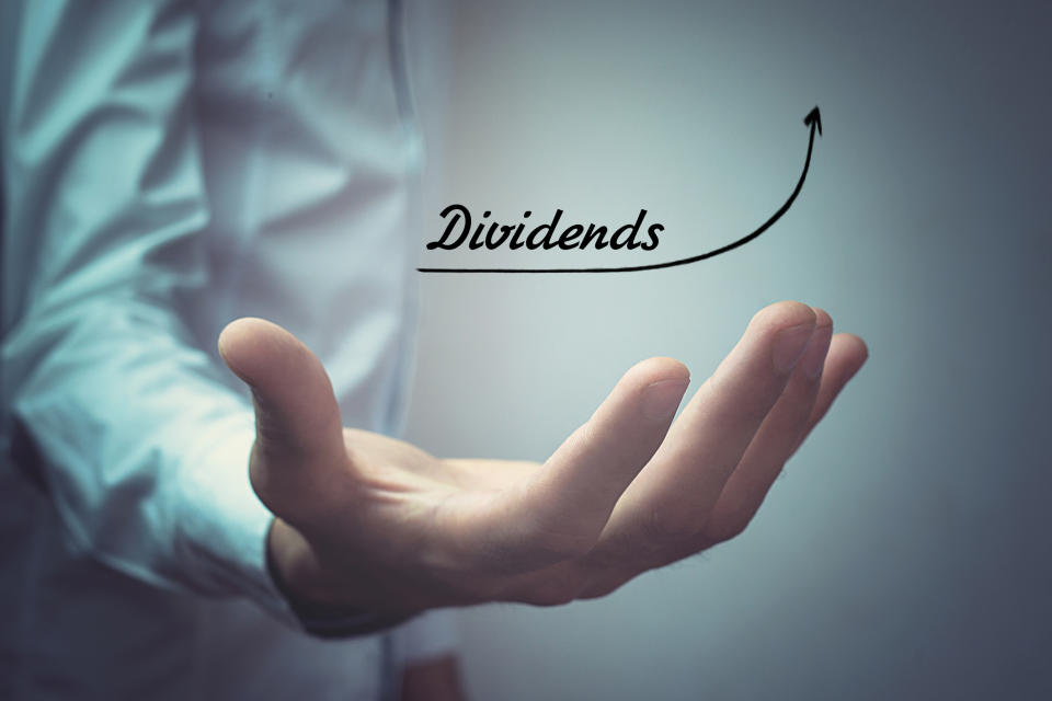 A person holding out their hand with the word dividends above and an arrow sloping upward.