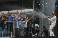 Formula One - F1 - Brazilian Grand Prix - Circuit of Interlagos, Sao Paulo, Brazil - 13/11/2016 - Mercedes' Lewis Hamilton of Britain sprays onlookers with champagne during the victory ceremony after winning the race. REUTERS/Nacho Doce