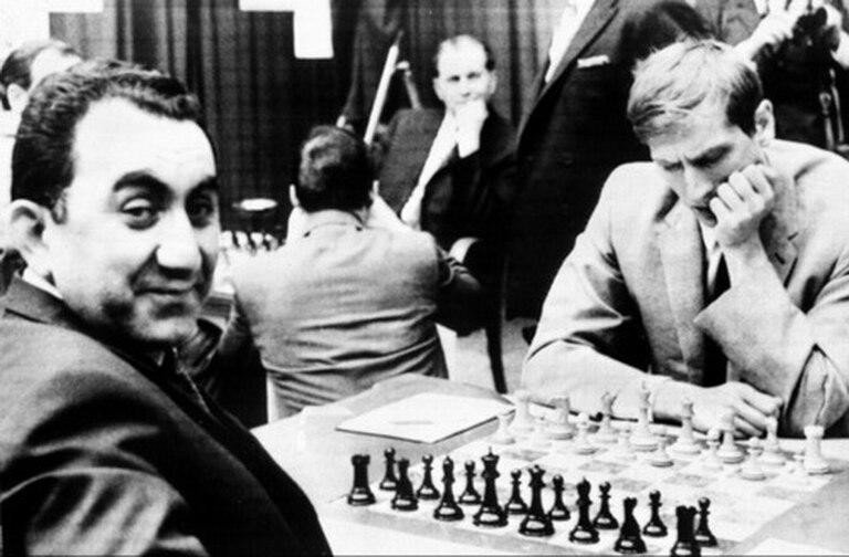 TIgran Petrosian sonríe mientras Bobby Fischer piensa antes de una partida del Mundial de ajedrez; el armenio y el estadounidense fueron dos cracks del juego-ciencia.