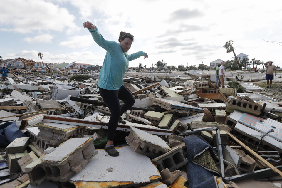 Mishelle McPherson climbs over the rubble of her friend's home. McPherson is searching for her friend because she knows she stayed in the home during Hurricane Michael.