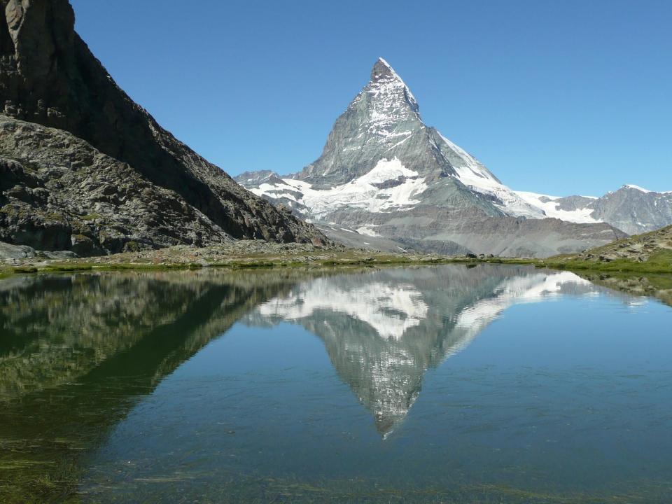 Zermatt, Switzerland, with the Matterhorn looming behind and reflected in a lake.