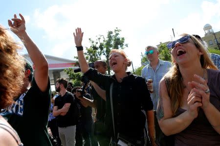 People cheer as a monument of Robert E. Lee, who was a general in the Confederate Army, is removed in New Orleans, Louisiana, U.S., May 19, 2017. REUTERS/Jonathan Bachman