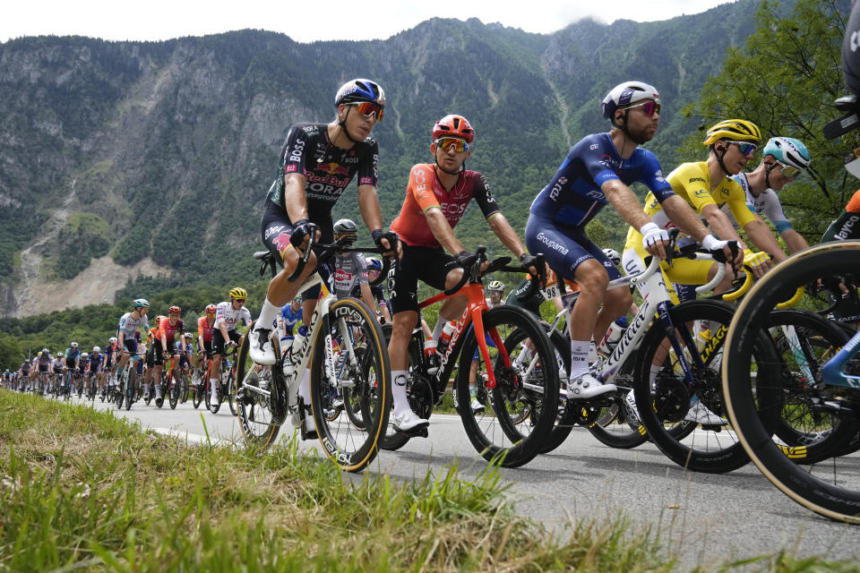 Slovenia's Tadej Pogacar, wearing the overall leader's yellow jersey, Poland's Michal Kwiatkowski, second left, and France's Clement Russo, third from right, rides in the pack during the fifth stage of the Tour de France cycling race over 177.4 kilometers (110.2 miles) with start in Saint-Jean-de-Maurienne and finish in Saint-Vulbas, France, Wednesday, July 3, 2024. (AP Photo/Jerome Delay)