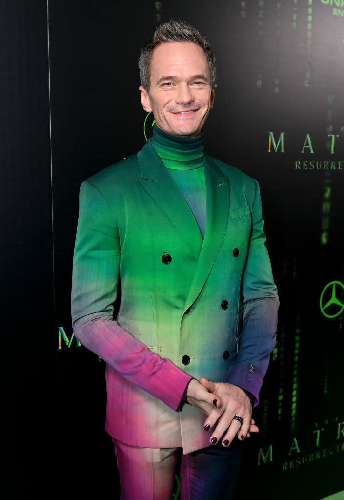 Neil wearing a custom suit in iridescent colors and dark nail polish at the matrix resurrections premiere