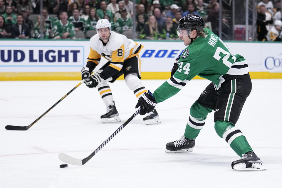 Dallas Stars center Roope Hintz (24) shoots and scores as Pittsburgh Penguins defenseman Brian Dumoulin (8) looks on in the first period of an NHL hockey game, Thursday, March 23, 2023, in Dallas. (AP Photo/Tony Gutierrez)