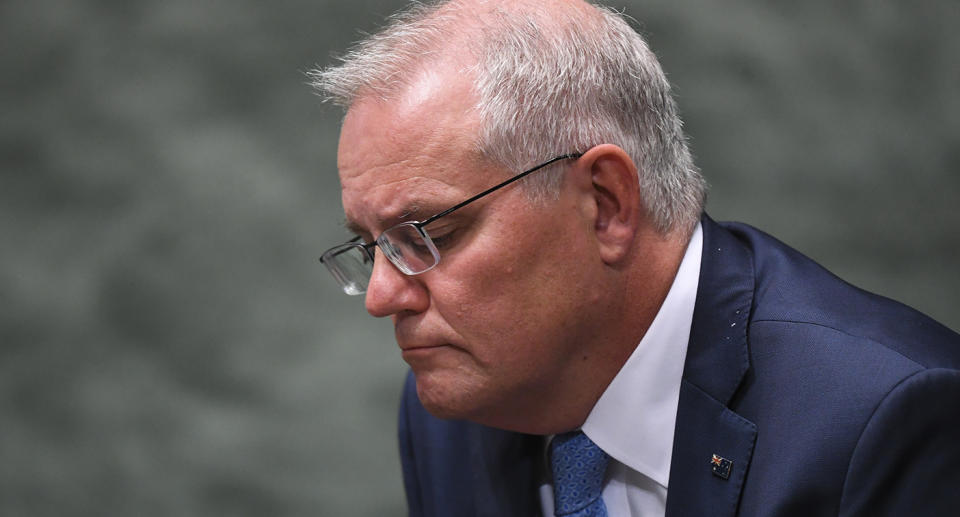 Australian Prime Minister Scott Morrison reacts during a statement of acknowledgment of harassment in the workplace of Commonwealth Parliament by the Speaker in the House of Representatives at Parliament House in Canberra, Tuesday, February 8, 2022. (AAP Image/Lukas Coch) NO ARCHIVING