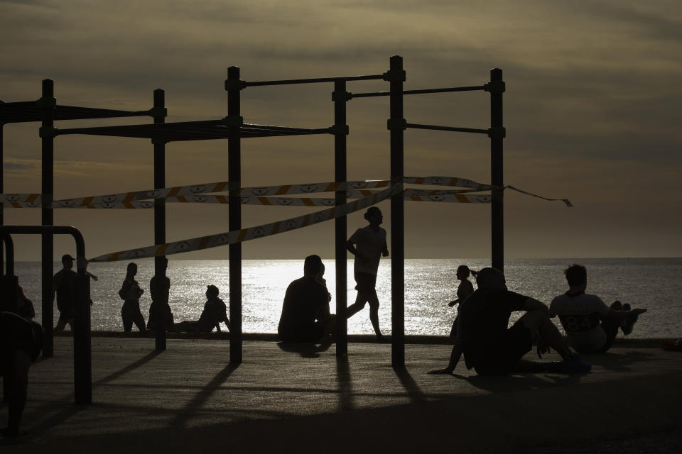 People exercises in a seafront promenade in Barcelona, Spain, Saturday, May 2, 2020. Spaniards have filled the streets of the country to do exercise for the first time after seven weeks of confinement in their homes to fight the coronavirus pandemic. People ran, walked, or rode bicycles under a brilliant sunny sky in Barcelona on Saturday, where many flocked to the maritime promenade to get as close as possible to the still off-limits beach. (AP Photo/Emilio Morenatti)