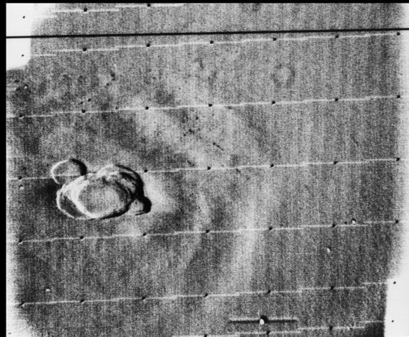 The Mariner 9 mission first saw the peak of Olympus Mons on Mars in the midst of a global dust storm in 1971.