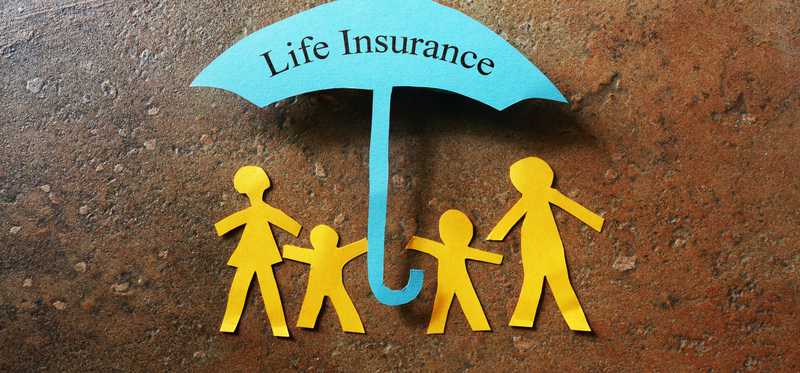 A paper cutout family under an umbrella that reads life insurance.