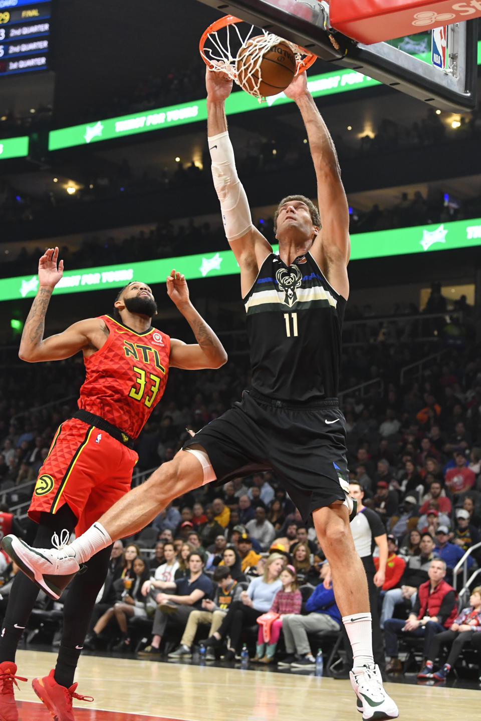 Milwaukee Bucks center Brook Lopez (11) dunks against Atlanta Hawks guard Allen Crabbe during the first half of an NBA basketball game Friday, Dec. 27, 2019, in Atlanta. (AP Photo/John Amis)