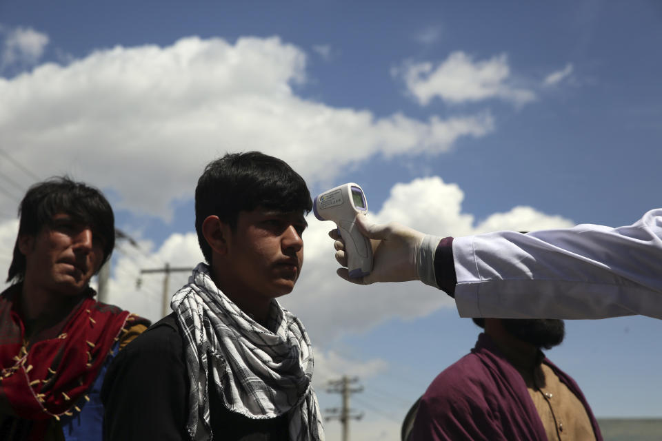 A health worker checks the temperature of car passengers in an effort to help prevent the spread of the coronavirus, as they enter the city in the Paghman district of Kabul, Afghanistan, Sunday, May 3, 2020. (AP Photo/Rahmat Gul)