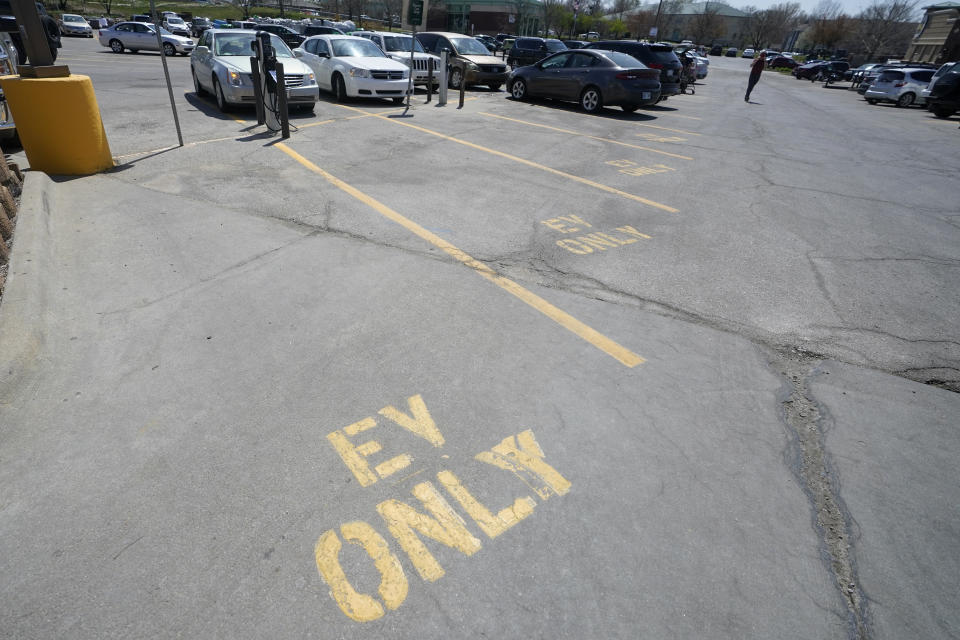 Four electric vehicle charging spots stand empty in a grocery story parking lot in Lawrence, Kan., Monday, April 5, 2021. The president and the auto industry maintain the nation is on the cusp of a gigantic shift to electric vehicles and away from liquid-fueled cars, but biofuels producers and some of their supporters in Congress aren’t buying it. They argue the U.S. should increase sales of ethanol and biodiesel, not abandon them. (AP Photo/Orlin Wagner)