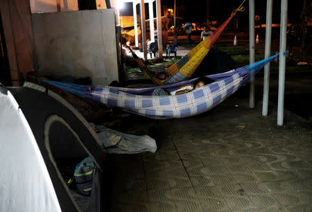 FILE PHOTO: Venezuelan people rest in hammocks along the street as they wait to show their passports or identity cards next day at the Pacaraima border control, Roraima state, Brazil August 9, 2018. Picture taken August 9, 2018. REUTERS/Nacho Doce