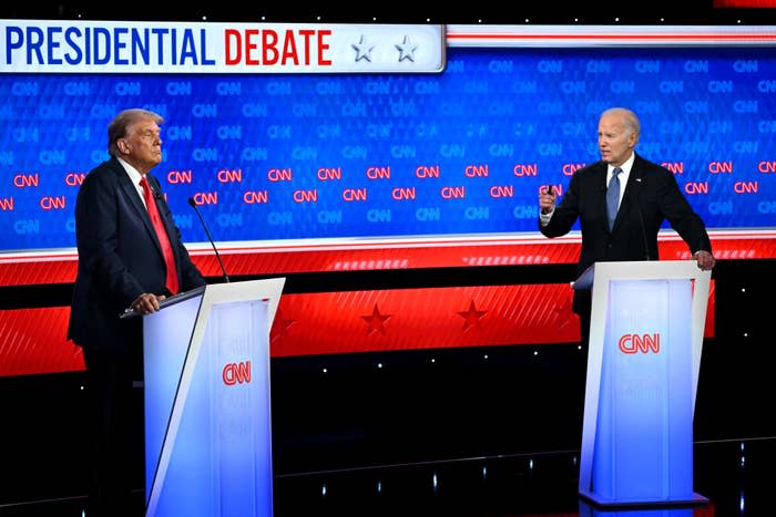 Donald Trump and Joe Biden stand at podiums during a CNN-hosted presidential debate, engaging in discussion. The background displays the text "Presidential Debate."