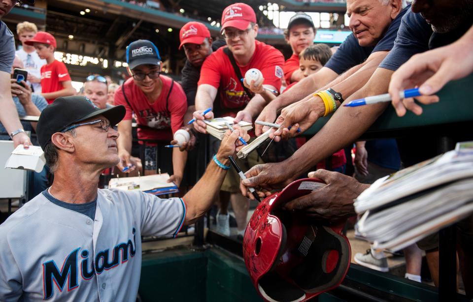 Then-Miami Marlins manager Don Mattingly signs autographs for fans before the start of a baseball game against the St. Louis Cardinals in 2019.