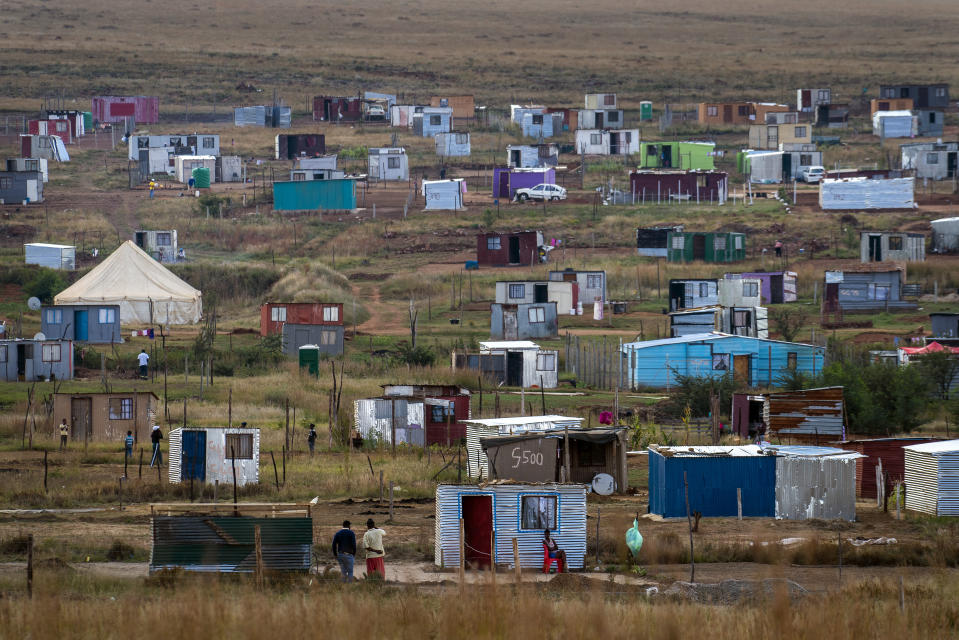 Residents of the Lawley informal settlement South West of Johannesburg, hang out outside Thursday April 23, 2020. Some residents have been accused of illegally erecting their structures on private land and were expelled earlier in the week, as South Africa is under a strict five-week lockdown in a effort to fight the Coronavirus pandemic.(AP Photo/Jerome Delay)