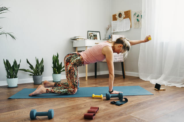 Slim woman stretching her legs on yoga mat. Female practicing yo stock photo