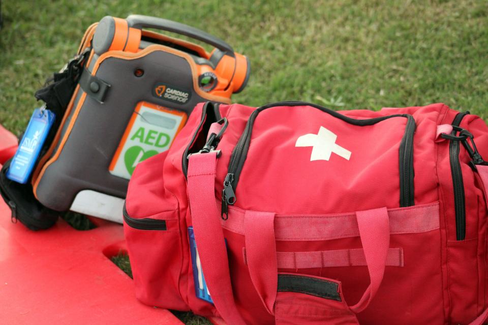 An automated external defibrillator (AED) and first-aid kit rest on the sidelines during a high school football game between Ponte Vedra and Mandarin on August 18, 2023. [Clayton Freeman/Florida Times-Union]