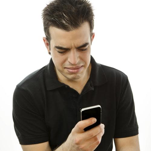 Man with pained expression looking at a smartphone