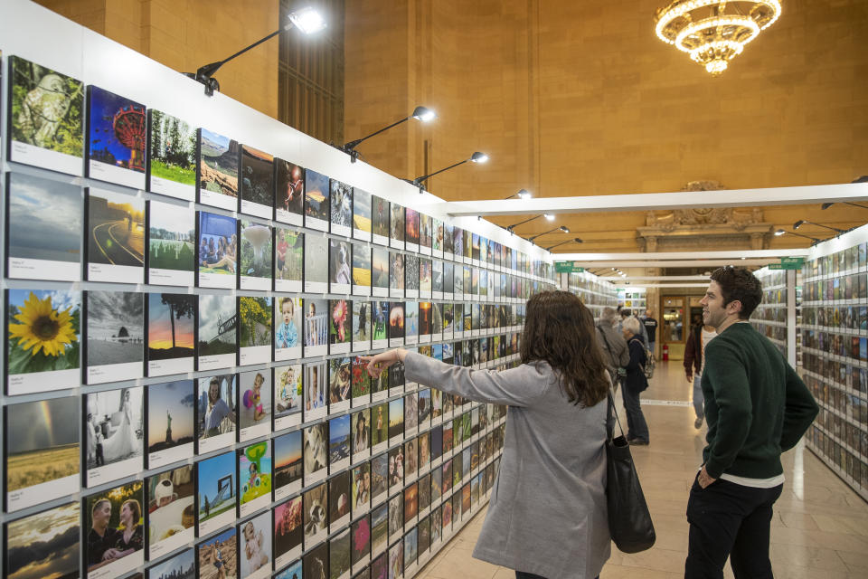 A woman acknowledges a photo she likes while attending the Fujifilm Printlife exhibit. (Photo: Gordon Donovan/Yahoo News)