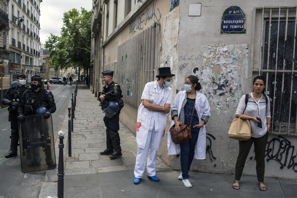 Hospital workers demonstrate on Bastille Day in Paris, Tuesday, July 14, 2020. French hospital workers are protesting to demand better pay and more investment in France's public hospital system, which is considered among the world's best but struggled to handle a flux of virus patients after years of cost cuts. (AP Photo/Rafael Yaghobzadeh)