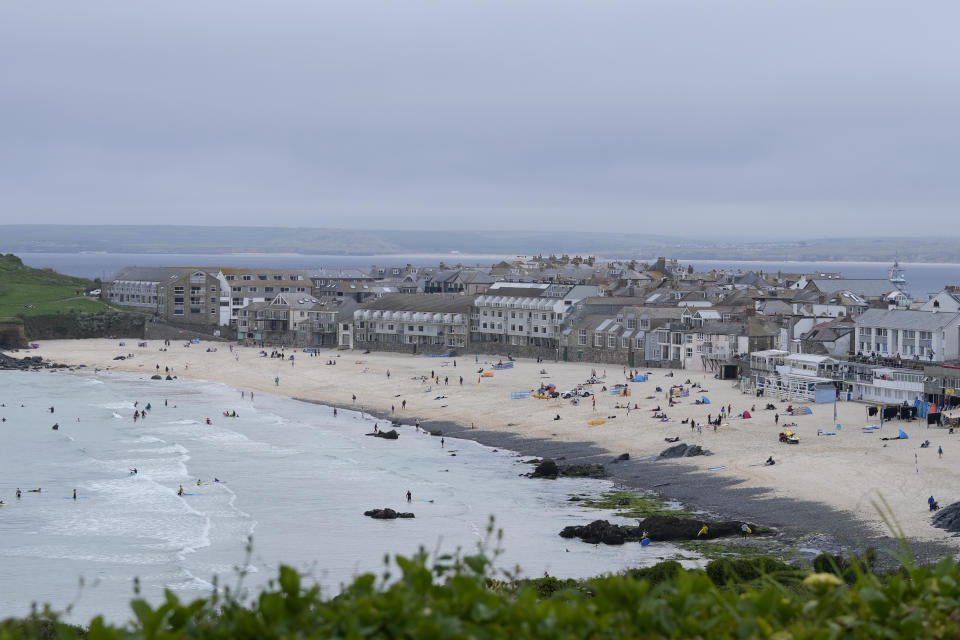 Surfers and sunbathers enjoy the beach at St. Ives, Cornwall, England, Thursday, June 10, 2021. G7 leaders and guests will meet in the the Cornish resort of Carbis Bay starting Friday, June 11, 2021. (AP Photo/Alastair Grant)