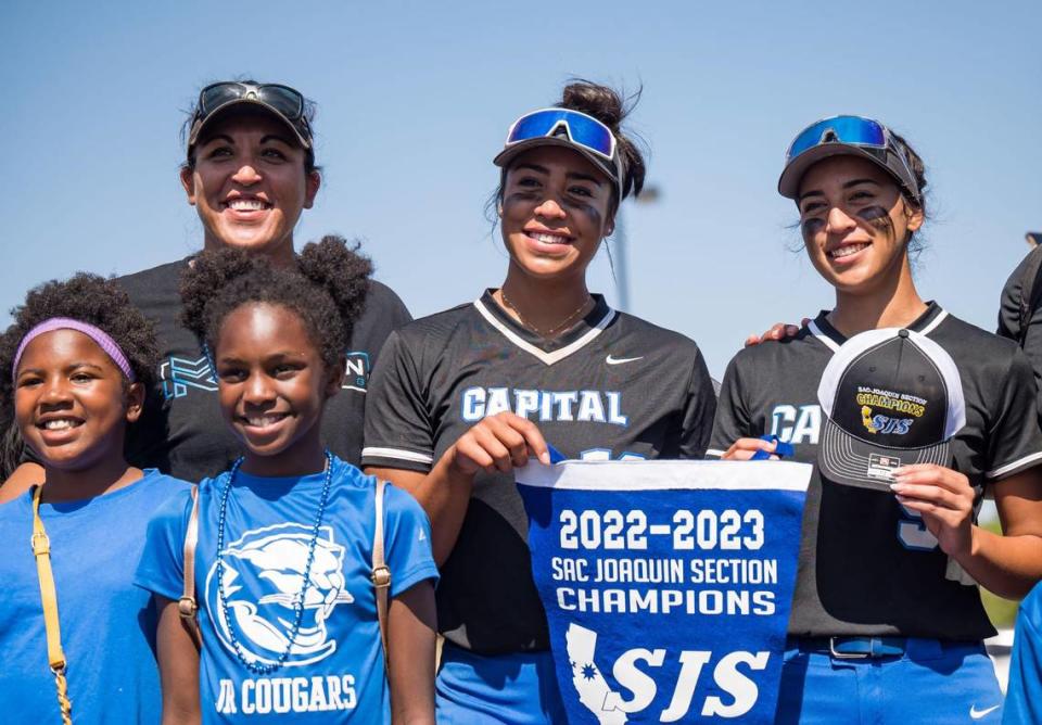 Shannon Tuua, left, stands for a photo with her daughters, Capital Christian Cougars pitcher Ayla Tuua (19), center, and third baseman Alannah Tuua (9), as they hold the section pennant after defeating the Dixon Rams for the CIF Sac-Joaquin Section Division IV high school softball championship title Saturday, May 27, 2023, at Cosumnes River College.