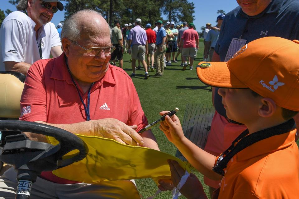 Broadcaster Verne Lundquist autographs a Masters flag for Jackson Heaton, 9 from Marietta, GA during Tuesday practice rounds at at Augusta National GC. (Photo: Michael Madrid-USA TODAY Sports)