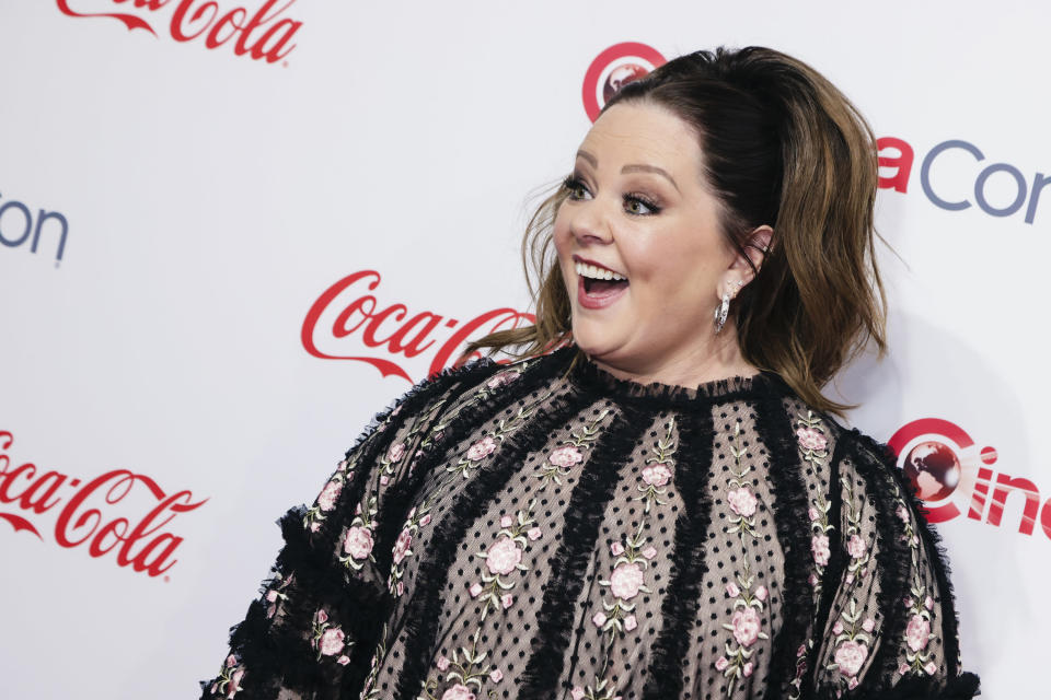melissa mccarthy smiles as she poses on a red carpet