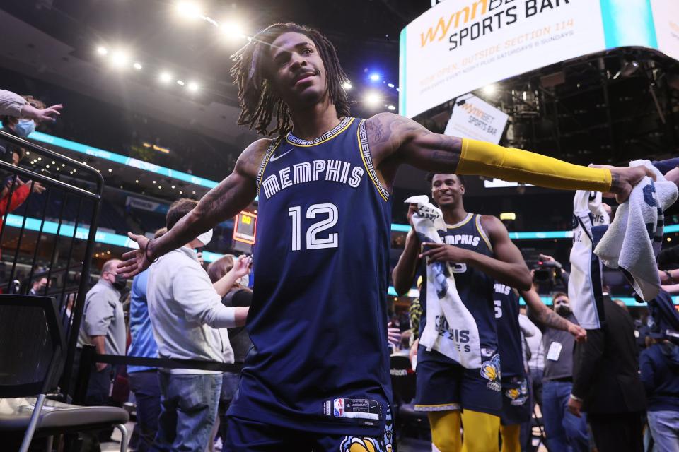 Memphis Grizzlies guard Ja Morant high-fives fans after their 119-109 win over the Utah Jazz at FedExForum on Friday, Jan. 28, 2022. 