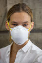 Israeli top model Bar Refaeli, center, wearing a face mask arrives to a court, in Tel Aviv, Israel, Monday, July 20, 2020. Refaeli signed a plea bargain agreement with authorities to settle a long-standing tax evasion case against her and her family. The deal will require Refaeli to serve nine months of community service while her mother, Zipi, will be sent to prison for 16 months. The two are also ordered to pay a $1.5 million fine on top of millions of back taxes owed to the state. (AP Photo/Oded Balilty, Pool)