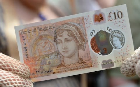 People in period costume pose with the new £10 note featuring Jane Austen - Credit: REUTERS/Chris J Ratcliffe