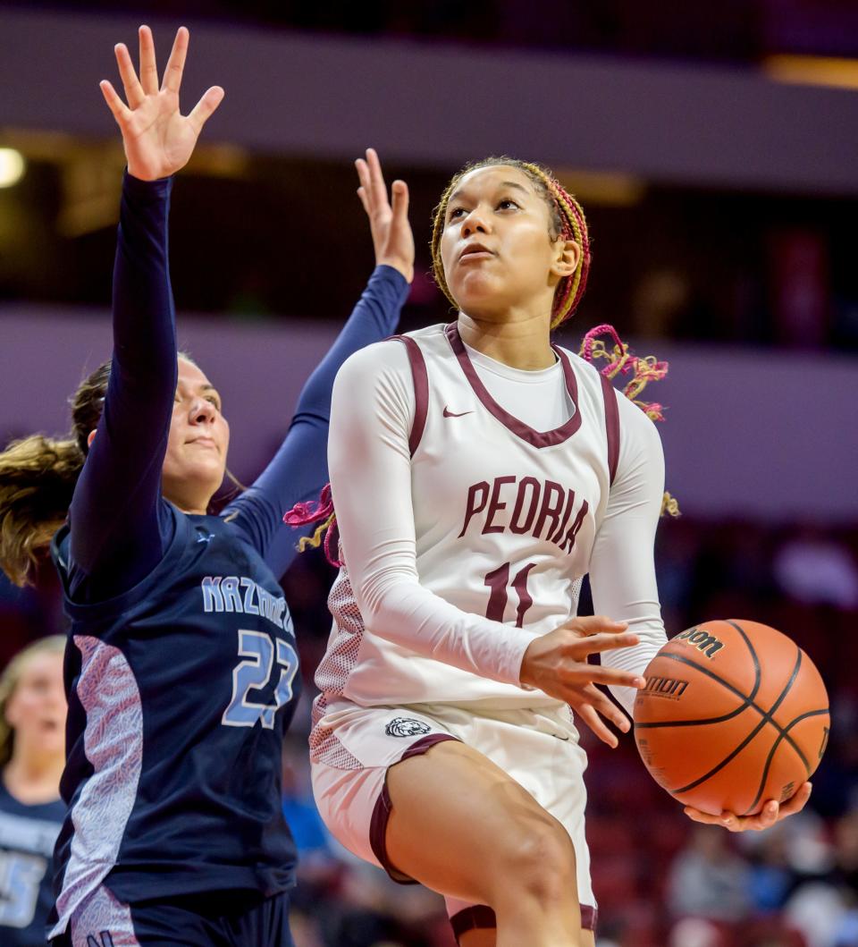Peoria High's Aaliyah Guyton, right, goes to the basket against Nazareth's Danielle Scully in the second half of the Class 3A state semifinals Friday, March 3, 2023 at CEFCU Arena in Normal. The Lions fell to the Roadrunners 48-35.