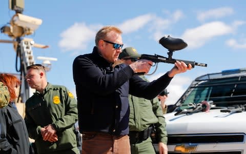 Acting Secretary of Defense Patrick Shanahan, center, fires a modified painted ball gun during a tour of the US-Mexico border