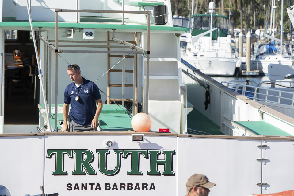 FBI agents search the Truth dive boat, a sister vessel to the Conception, as authorities issue a search warrant for the Truth Aquatics' offices on the Santa Barbara Harbor in Santa Barbara, Calif., Sunday, Sept. 8, 2019. The office was ringed in red "crime scene" tape as more than a dozen agents took photos and carried out boxes. Thirty-four people died when the Conception burned and sank before dawn on Sept. 2. They were sleeping in a cramped bunkroom below the main deck and their escape routes were blocked by fire. (AP Photo/Christian Monterrosa)