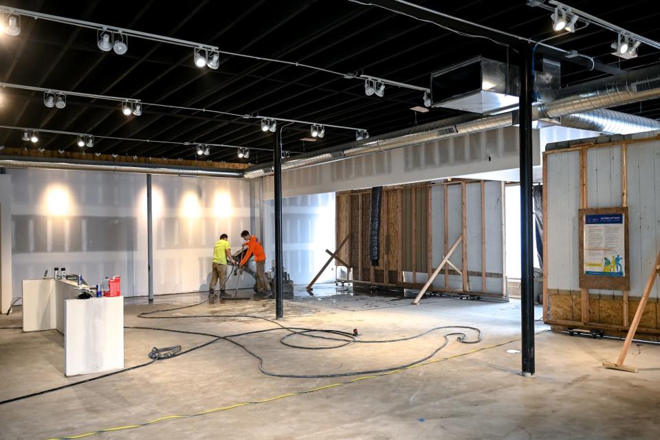 A crew works inside Moneyball Sportswear's new headquarters on Tuesday, May 2, 2023, in Lansing.