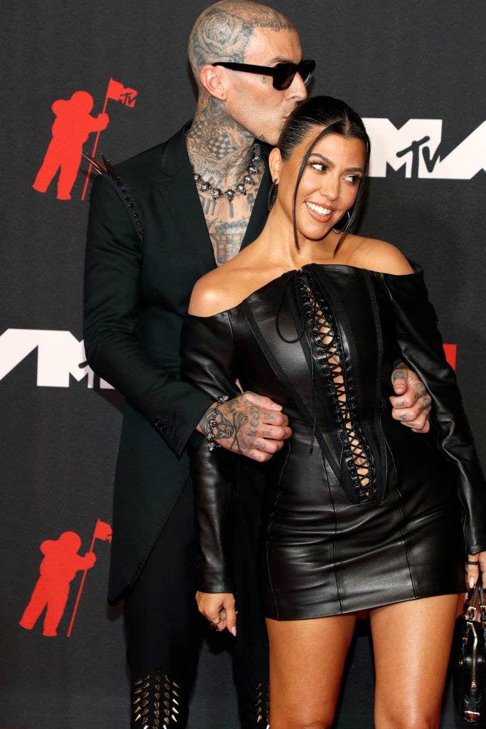 (L-R) Travis Barker with his arms around Kourtney Kardashian as he kisses her head