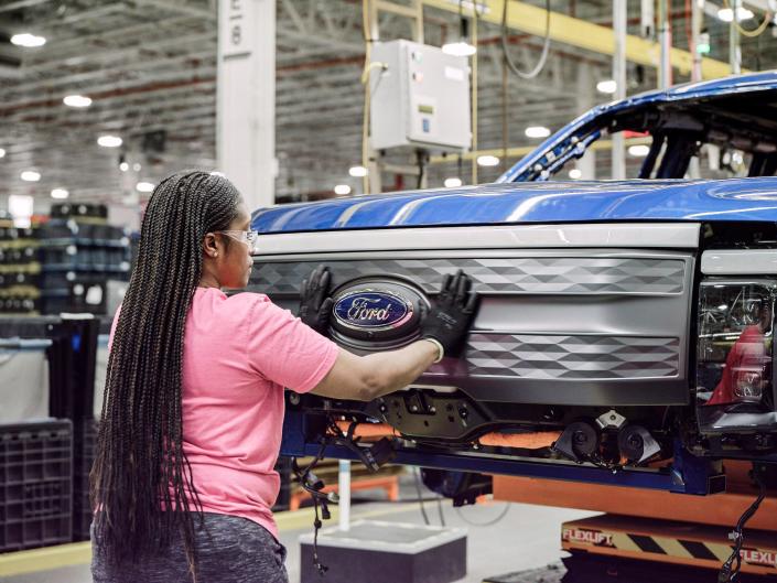 A Ford assembly worker with an electric F-150 Lightning