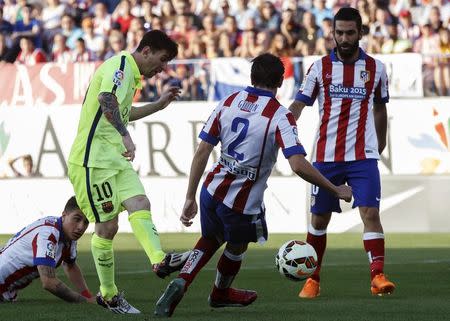 Barcelona's Lionel Messi (L) kicks to score during their Spanish first division soccer match against Atletico Madrid at Vicente Calderon stadium in Madrid, Spain, May 17, 2015. REUTER/Juan Medina