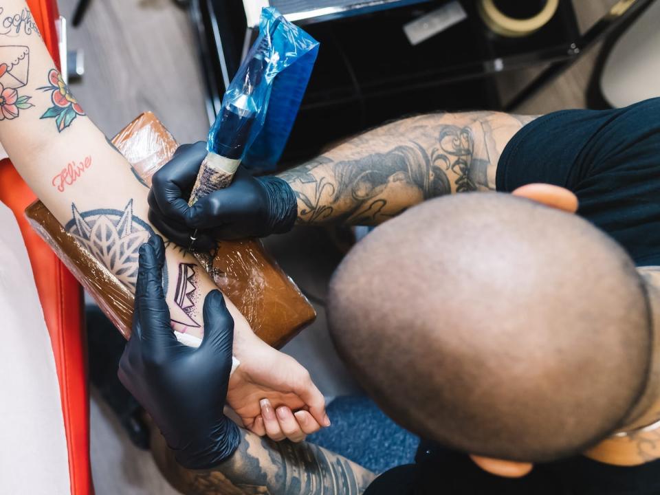 A person gets a tattoo on their arm.