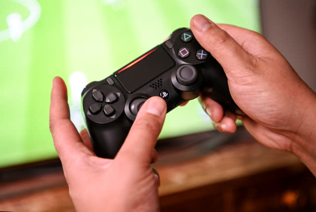 02 April 2020, Berlin: A young man plays with the game console Playstation 4. to prevent infection with the corona virus, many people spend their free time at home. Photo: Britta Pedersen/dpa-Zentralbild/dpa (Photo by Britta Pedersen/picture alliance via Getty Images)