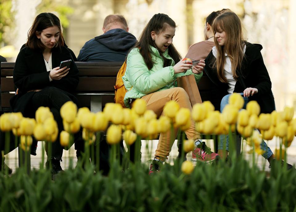 People talk and look at their phones in Lviv Oblast of western Ukraine on Friday, May 5, 2023. | Scott G Winterton, Deseret News