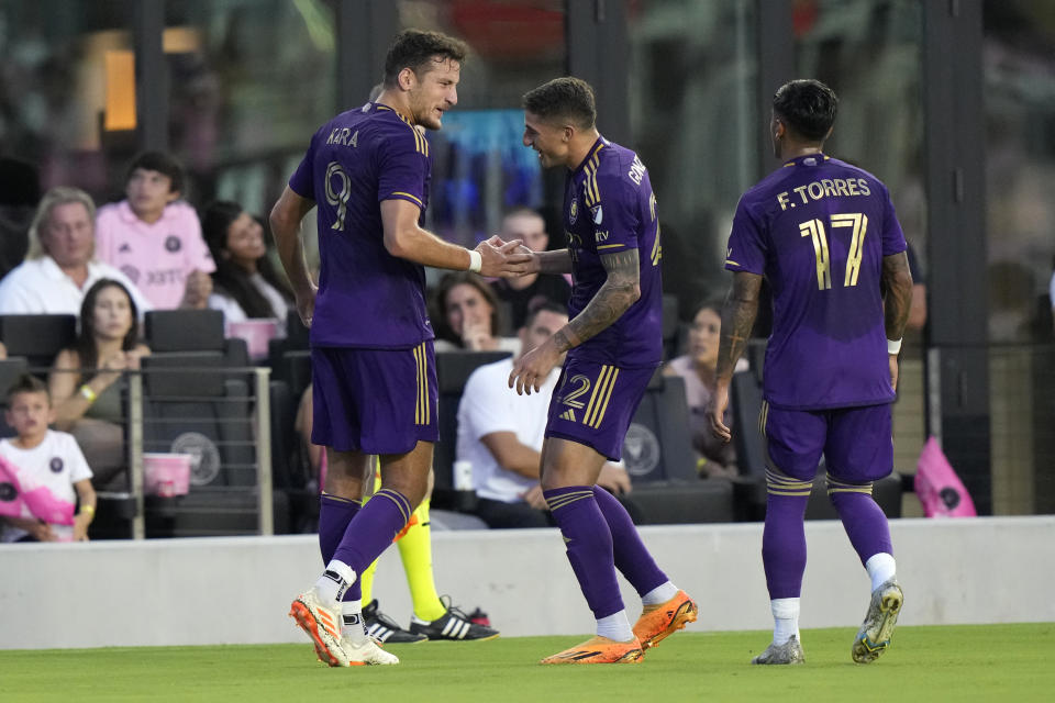 Orlando City forward Ercan Kara (9) shakes hands with forward Gastón González, center, after scoring a goal during the first half of an MLS soccer match against Inter Miami, Saturday, May 20, 2023, in Fort Lauderdale, Fla. (AP Photo/Lynne Sladky)