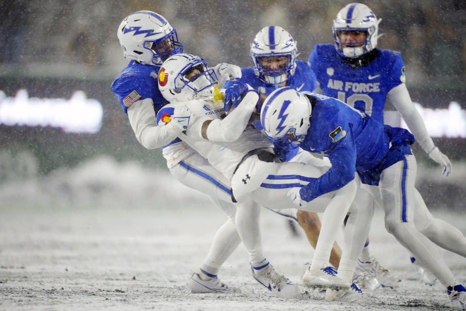 Colorado State wide receiver Tory Horton, second from left, is stopped by Air Force linebacker Johnathan Youngblood, left, and safety Jayden Goodwin, front right, after catching a pass in the second half of an NCAA college football game in the snow Saturday, Oct. 28, 2023, in Fort Collins, Colo. (AP Photo/David Zalubowski)