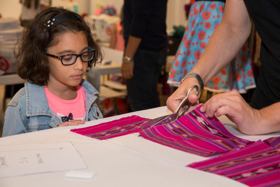 A teached helps prepare one camper’s patchwork.