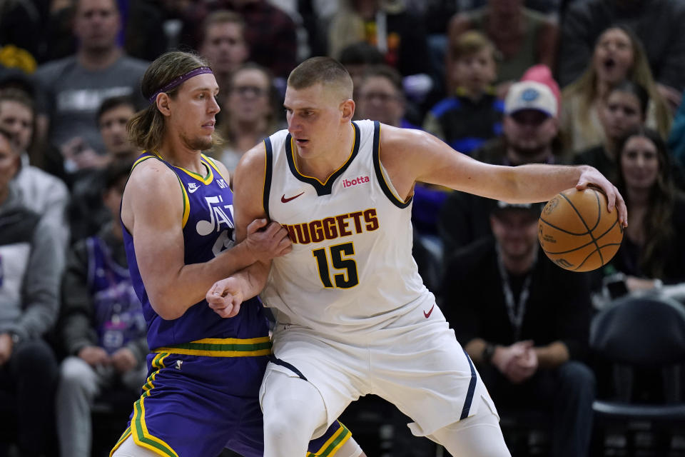 Utah Jazz forward Kelly Olynyk, left, guards Denver Nuggets center Nikola Jokic (15) during the second half of an NBA basketball game Wednesday, Jan. 10, 2024, in Salt Lake City. (AP Photo/Rick Bowmer)