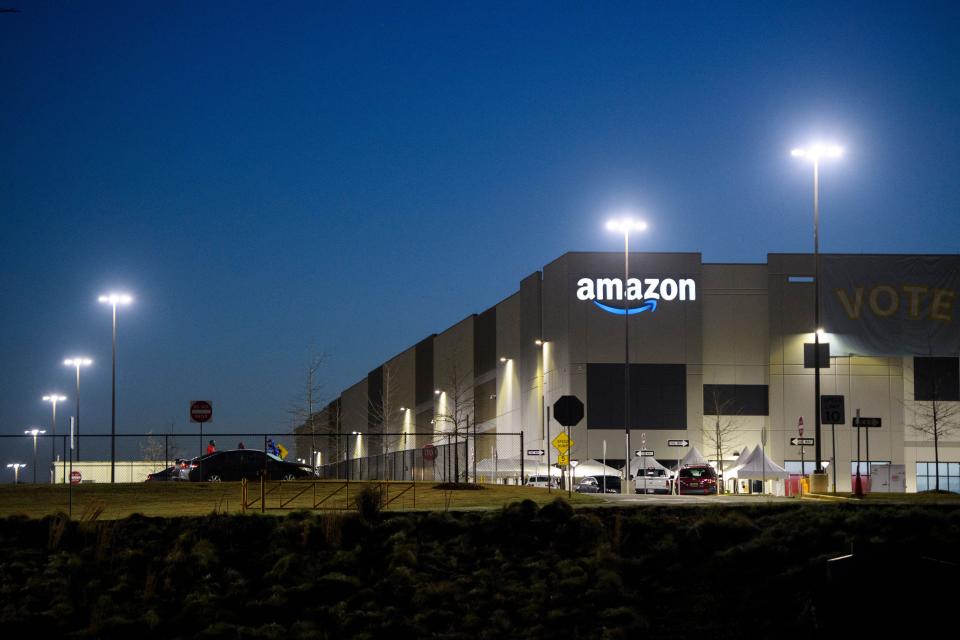 The Bessemer, Alabama Amazon warehouse at dusk, with a "Vote" sign on the side of the building.