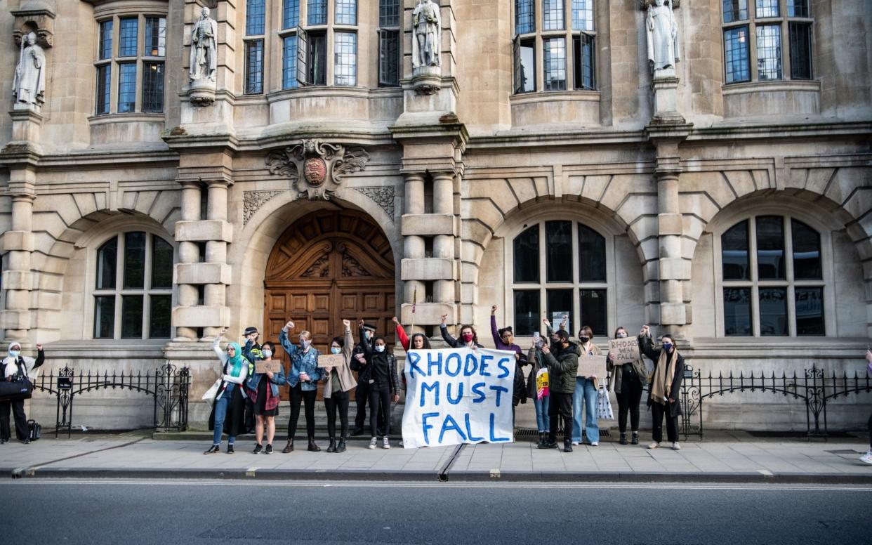 Protesters march to Oriel Colleges statue of Cecil Rhodes at the University of Oxford on May 25, 2021  - Laurel Chor/Getty